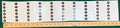 Clear vinyl sheet of dry-erase slot number price stickers, slots 10 to 69, next to a yardstick
